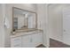 Bright bathroom featuring a granite countertop, white cabinetry, and a large vanity mirror at 18916 W Laurel Ln, Surprise, AZ 85388