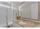Bathroom featuring granite countertops, white cabinets, white tile and a glass shower enclosure at 18916 W Laurel Ln, Surprise, AZ 85388