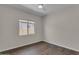 Cozy bedroom with wood-look tile flooring, a window, and neutral wall paint at 18916 W Laurel Ln, Surprise, AZ 85388