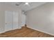 A bedroom features wood-look flooring, a ceiling fan, and a double-door closet at 18916 W Laurel Ln, Surprise, AZ 85388