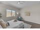 Relaxing bedroom with a large window, seating, floral wall art, and decorative pillows and throws at 18916 W Laurel Ln, Surprise, AZ 85388