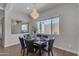 Formal dining room with a chandelier, views of the outdoor surroundings, and a sleek table at 18916 W Laurel Ln, Surprise, AZ 85388