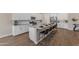 Modern kitchen with stainless appliances, a large island with seating, and white cabinetry throughout at 18916 W Laurel Ln, Surprise, AZ 85388