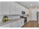 Modern kitchen featuring white cabinets, subway tile backsplash, and stainless steel appliances at 18916 W Laurel Ln, Surprise, AZ 85388