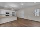 Open-concept living room features wood-look tile flooring and a kitchen with stainless steel appliances at 18916 W Laurel Ln, Surprise, AZ 85388