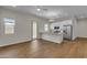 The living room offers an open floorplan, wood-look floors, and white kitchen cabinets at 18916 W Laurel Ln, Surprise, AZ 85388