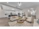 Open-concept living room with seamless flow to kitchen, featuring neutral paint and wood-look tile flooring at 18916 W Laurel Ln, Surprise, AZ 85388