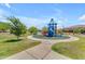 Community playground area with a blue playset, walking path and landscaping at 18916 W Laurel Ln, Surprise, AZ 85388