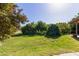 Backyard showcasing lush, green grass and mature trees, providing a serene outdoor setting at 19006 E Karsten Dr, Queen Creek, AZ 85142