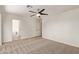 The bedroom has carpet flooring, ceiling fan and a view into the on-suite bathroom at 19006 E Karsten Dr, Queen Creek, AZ 85142