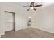 This bedroom features carpet, a ceiling fan, and a closet with sliding doors at 19006 E Karsten Dr, Queen Creek, AZ 85142