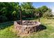 Backyard brick firepit surrounded by mature bushes and trees at 19006 E Karsten Dr, Queen Creek, AZ 85142
