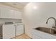 The laundry room features a sink, ample storage, and a washer and dryer at 19006 E Karsten Dr, Queen Creek, AZ 85142