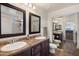 Elegant bathroom with dual sinks, wood cabinets, and a large framed mirror at 2004 E Heartwood Ln, Phoenix, AZ 85022