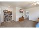 Open bedroom area featuring a bookshelf, mounted television, and neutral carpeting at 2004 E Heartwood Ln, Phoenix, AZ 85022