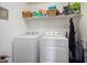 Organized laundry room with side by side washer and dryer, and wire shelving at 2004 E Heartwood Ln, Phoenix, AZ 85022