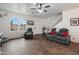 Cozy living room with modern flooring, a ceiling fan, and plenty of natural light through arched windows at 2004 E Heartwood Ln, Phoenix, AZ 85022