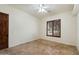 This bedroom offers neutral walls, tile floors, a ceiling fan, and a window with wood-slat blinds at 21205 E Excelsior Ave, Queen Creek, AZ 85142