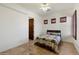 Comfortable bedroom with a cozy bed, tile floors, three shuttered windows and a closet with dark wood door at 21205 E Excelsior Ave, Queen Creek, AZ 85142