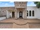 Stone entryway featuring arched windows, exterior lanterns, and a custom iron gate at 21205 E Excelsior Ave, Queen Creek, AZ 85142