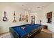 Entertaining game room with pool table, custom wet bar, arched doorways, and custom display shelves for musical instruments at 21205 E Excelsior Ave, Queen Creek, AZ 85142