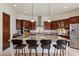 Spacious kitchen island featuring granite countertops, custom cabinetry, and seating at 21205 E Excelsior Ave, Queen Creek, AZ 85142