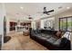 Spacious living room with a large leather sectional sofa, open to the gourmet kitchen with bar seating at 21205 E Excelsior Ave, Queen Creek, AZ 85142