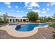 This backyard features a large pool, spa, desert landscaping, and covered patio seating at 21205 E Excelsior Ave, Queen Creek, AZ 85142