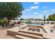 Backyard pool area with desert landscaping, a fire pit, patio seating and mountain views at 21205 E Excelsior Ave, Queen Creek, AZ 85142