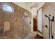 Luxurious walk-in shower with travertine tile, built-in shower seat, and glass block window for natural light at 21205 E Excelsior Ave, Queen Creek, AZ 85142