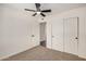 This bedroom features neutral carpet, a ceiling fan, and a closet with sliding doors at 2124 E Boston St, Chandler, AZ 85225
