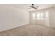 Bright bedroom featuring neutral carpet, a ceiling fan and a large window at 2124 E Boston St, Chandler, AZ 85225