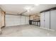This garage features a roll-up door and workbench with storage cabinets and shelving at 2124 E Boston St, Chandler, AZ 85225