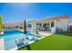 Beautiful backyard with a pool, covered patio, outdoor kitchen, and lush landscaping, perfect for entertaining at 21449 W Mariposa St, Buckeye, AZ 85396