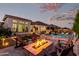 Outdoor entertaining space featuring a pool, built-in grill, and a cozy fire pit with seating at 21449 W Mariposa St, Buckeye, AZ 85396