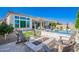 A beautiful backyard features a pool, spa, outdoor kitchen, fire pit, and lounge chairs at 21449 W Mariposa St, Buckeye, AZ 85396