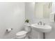 Modern powder room with pedestal sink, toilet and light gray walls at 21449 W Mariposa St, Buckeye, AZ 85396