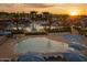 Gorgeous community pool with multiple sun umbrellas and lounge chairs at sunset at 21449 W Mariposa St, Buckeye, AZ 85396