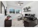 Bright home office with a large window, comfortable chair, and a modern ceiling fan at 21449 W Mariposa St, Buckeye, AZ 85396