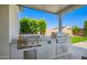 An outdoor kitchen features stainless steel grill appliances and granite countertops at 21449 W Mariposa St, Buckeye, AZ 85396