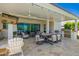Spacious covered patio featuring multiple seating areas, an outdoor kitchen, and travertine flooring at 21449 W Mariposa St, Buckeye, AZ 85396
