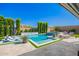 Backyard oasis with a sparkling pool, spa, lush landscaping, and comfortable lounge chairs at 21449 W Mariposa St, Buckeye, AZ 85396