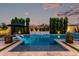 Backyard pool area with lounge chairs, lush green landscaping and privacy wall, perfect for relaxation at 21449 W Mariposa St, Buckeye, AZ 85396