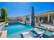 Luxurious pool area with lounge chairs and an umbrella, providing a perfect spot for relaxation and fun at 21449 W Mariposa St, Buckeye, AZ 85396