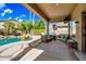 Inviting covered back patio with comfortable seating area overlooking a sparkling pool and lush landscaping at 2156 W Periwinkle Way, Chandler, AZ 85248