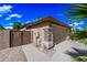 Tan house with stone accents, a two-car garage, a gravel yard, and wood gate on a sunny day at 2156 W Periwinkle Way, Chandler, AZ 85248