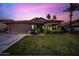 Beautiful home at twilight with lush green grass, desert landscaping, and a two-car garage at 2156 W Periwinkle Way, Chandler, AZ 85248