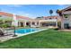 Beautiful backyard featuring a pool, green lawn, and white stucco home with a red tile roof at 2339 E Virgo Pl, Chandler, AZ 85249