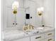 Marble vanity with gold fixtures in a well-lit bathroom; sconces flank large mirrors at 2339 E Virgo Pl, Chandler, AZ 85249