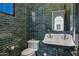 Charming bathroom with dark green tiled walls, a toilet, and a stylish sink, creating a classic look at 2339 E Virgo Pl, Chandler, AZ 85249